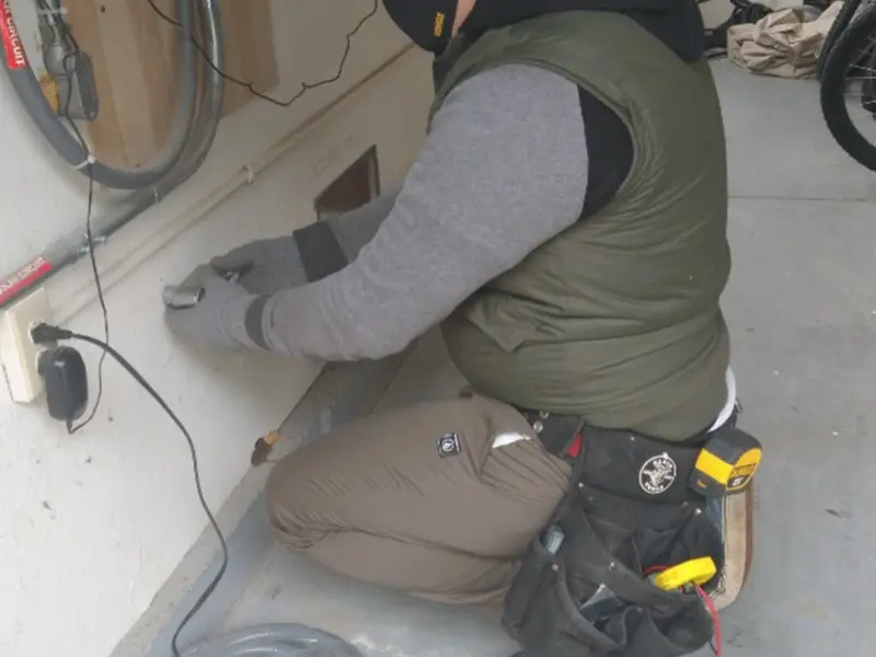 Electrician performing outlet wiring in a Coolidge garage